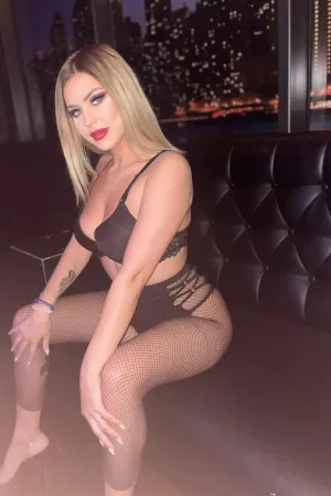 Tania sitting on the sofa in her black lingerie 